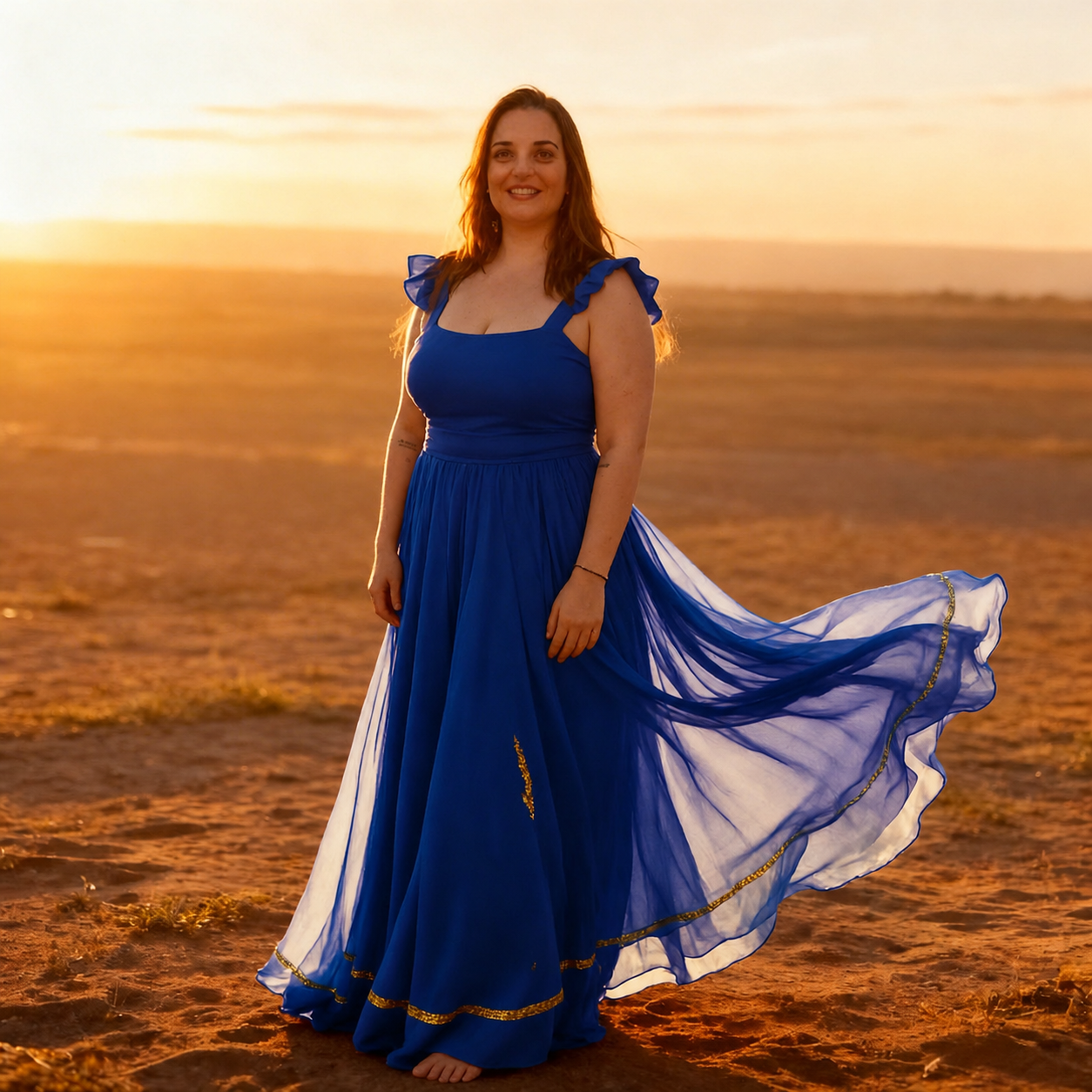 Karina Stoco, autora do e-book, em vestido azul ao pôr do sol